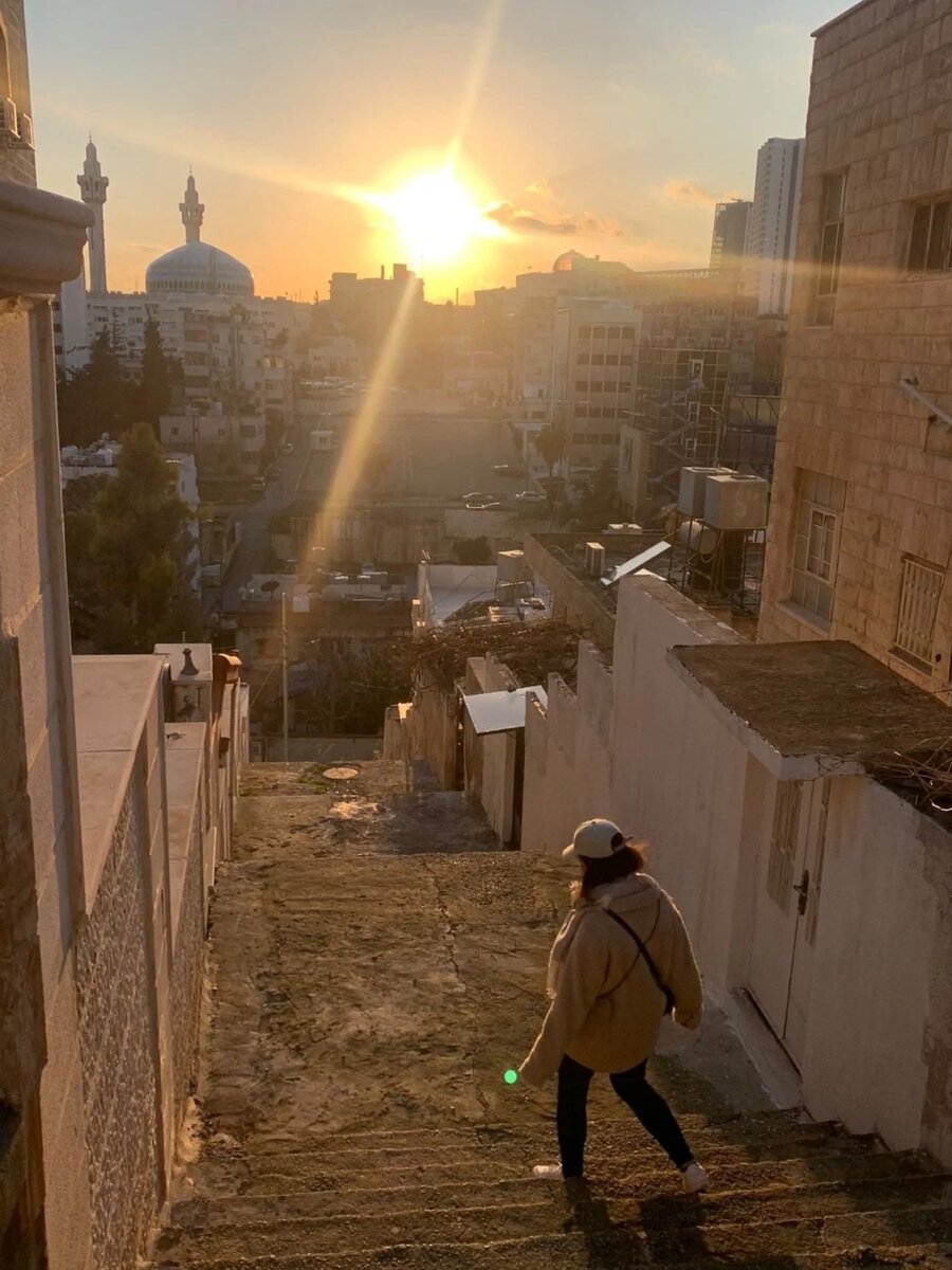 Laís Martins descendo uma escadaria ao pôr do sol